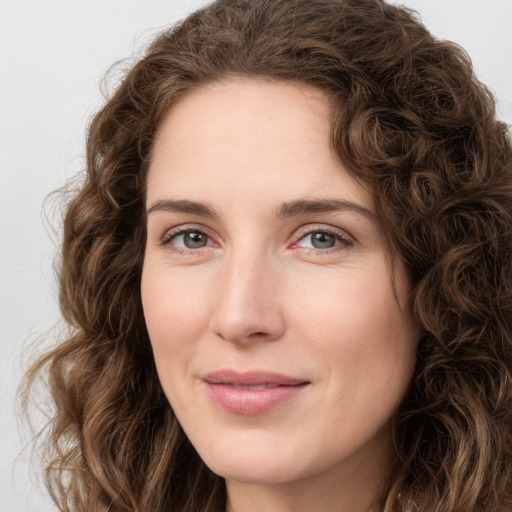 Joyful white young-adult female with long  brown hair and green eyes