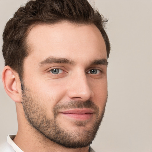 Joyful white young-adult male with short  brown hair and grey eyes