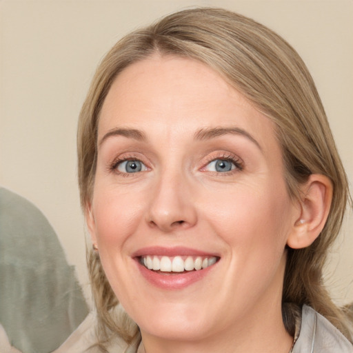 Joyful white young-adult female with medium  brown hair and blue eyes