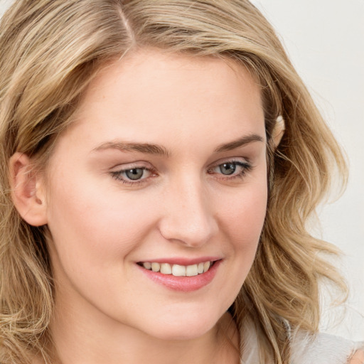 Joyful white young-adult female with long  brown hair and blue eyes