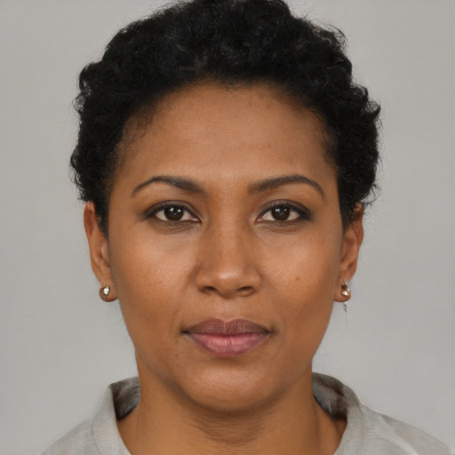 Joyful black adult female with short  black hair and brown eyes