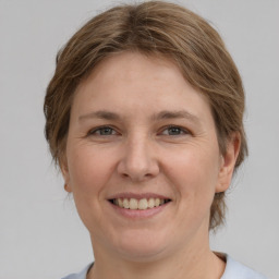 Joyful white adult female with medium  brown hair and grey eyes