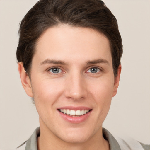 Joyful white young-adult female with short  brown hair and grey eyes