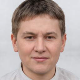 Joyful white young-adult male with short  brown hair and grey eyes