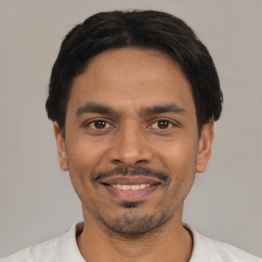 Joyful latino young-adult male with short  black hair and brown eyes