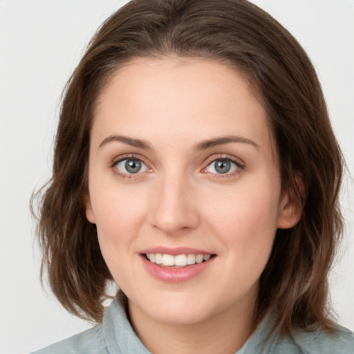 Joyful white young-adult female with medium  brown hair and blue eyes