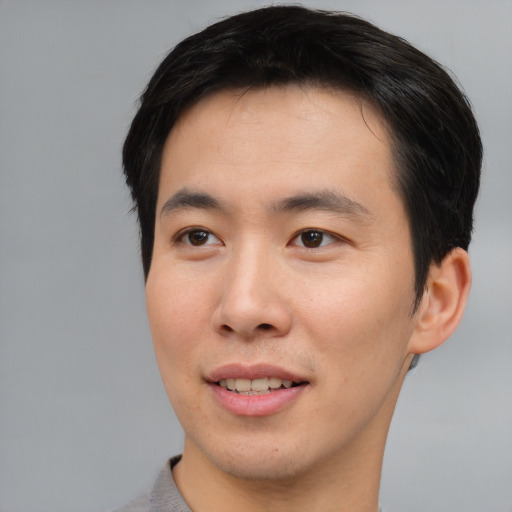 Joyful asian young-adult male with short  brown hair and brown eyes