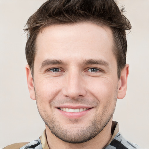 Joyful white young-adult male with short  brown hair and grey eyes