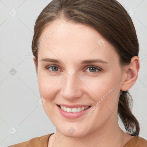 Joyful white young-adult female with medium  brown hair and grey eyes