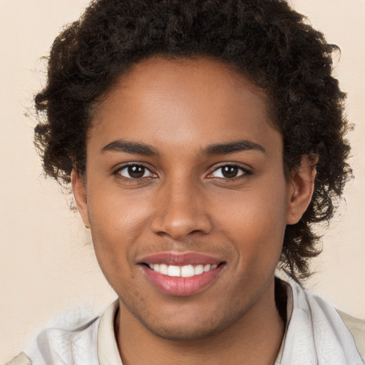 Joyful black young-adult female with short  brown hair and brown eyes