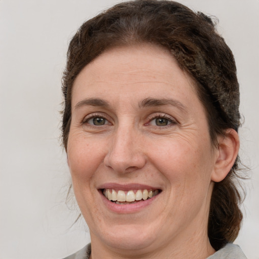 Joyful white adult female with medium  brown hair and grey eyes