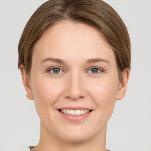 Joyful white young-adult female with short  brown hair and grey eyes