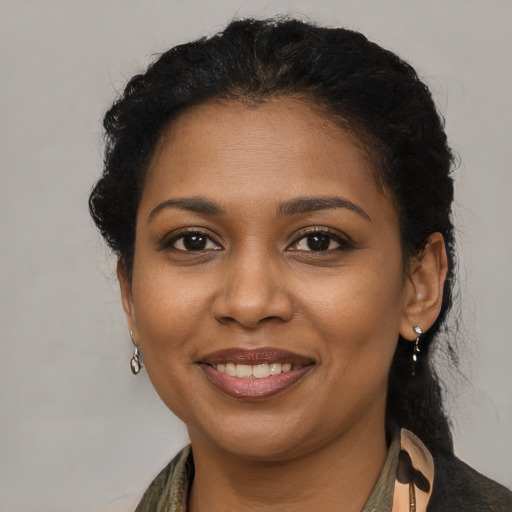 Joyful black young-adult female with long  brown hair and brown eyes