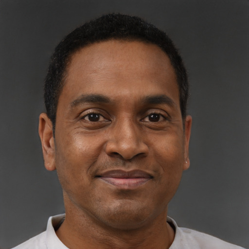 Joyful black adult male with short  brown hair and brown eyes