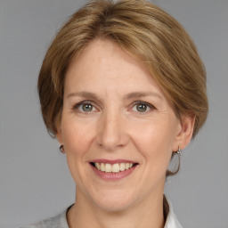 Joyful white adult female with medium  brown hair and grey eyes