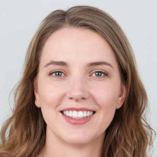 Joyful white young-adult female with long  brown hair and blue eyes