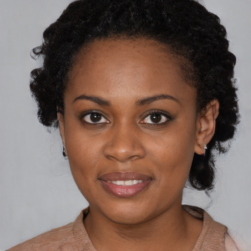 Joyful black young-adult female with short  black hair and brown eyes