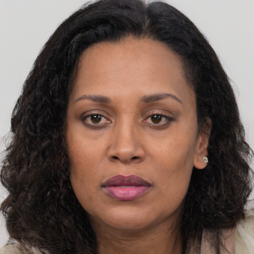 Joyful black adult female with long  brown hair and brown eyes