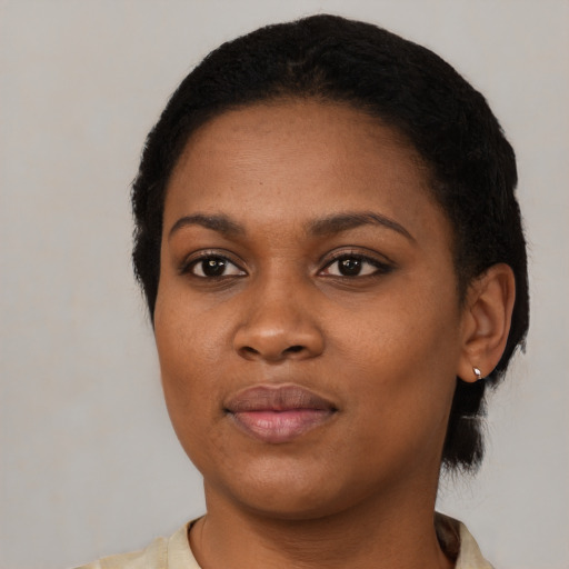 Joyful black young-adult female with short  black hair and brown eyes
