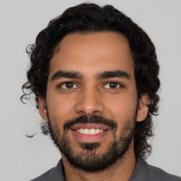 Joyful latino young-adult male with short  black hair and brown eyes