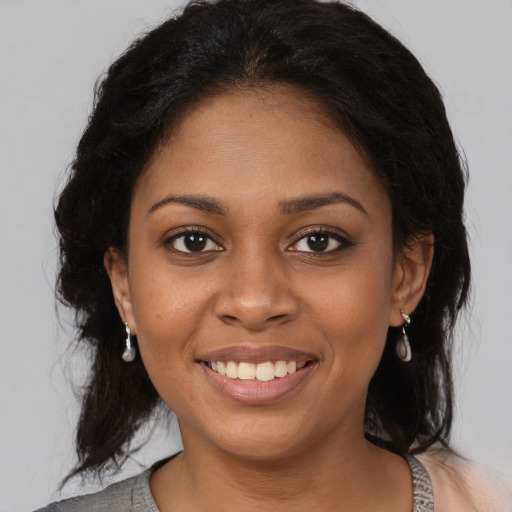 Joyful black young-adult female with medium  brown hair and brown eyes