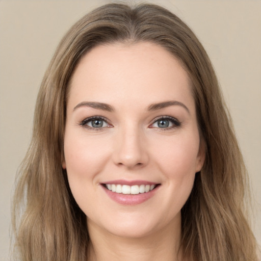 Joyful white young-adult female with long  brown hair and green eyes