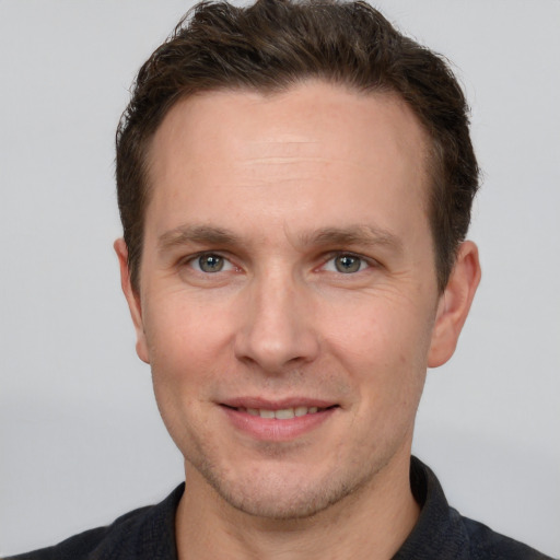 Joyful white adult male with short  brown hair and grey eyes