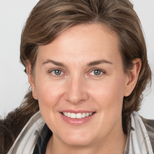 Joyful white adult female with medium  brown hair and grey eyes