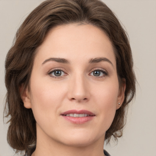 Joyful white young-adult female with medium  brown hair and grey eyes