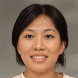 Joyful asian young-adult female with medium  brown hair and brown eyes