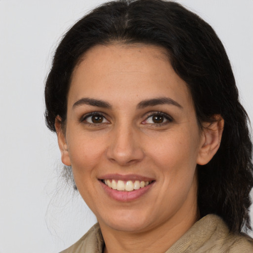 Joyful latino young-adult female with medium  brown hair and brown eyes