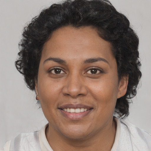 Joyful black adult female with short  black hair and brown eyes