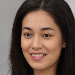 Joyful asian young-adult female with long  brown hair and brown eyes