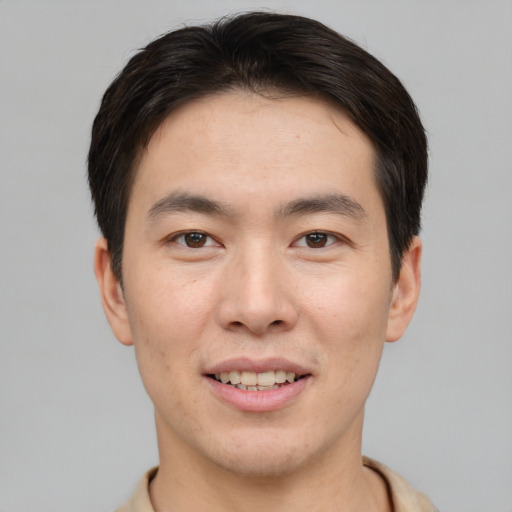Joyful asian young-adult male with short  brown hair and brown eyes