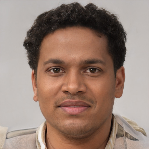 Joyful black young-adult male with short  brown hair and brown eyes