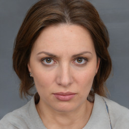 Joyful white young-adult female with medium  brown hair and blue eyes