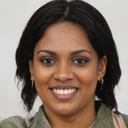 Joyful black young-adult female with medium  brown hair and brown eyes