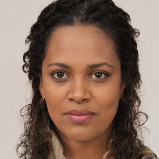 Joyful black young-adult female with long  brown hair and brown eyes