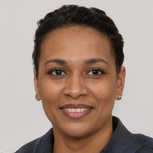 Joyful black young-adult female with short  black hair and brown eyes