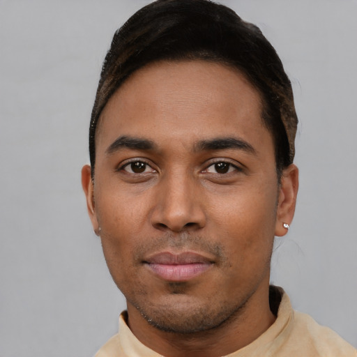 Joyful latino young-adult male with short  brown hair and brown eyes