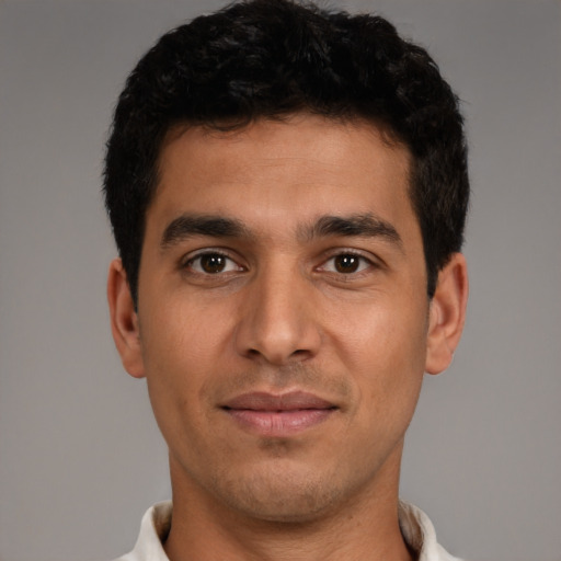 Joyful white young-adult male with short  black hair and brown eyes