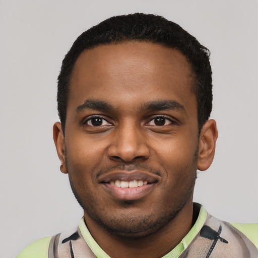 Joyful black young-adult male with short  black hair and brown eyes