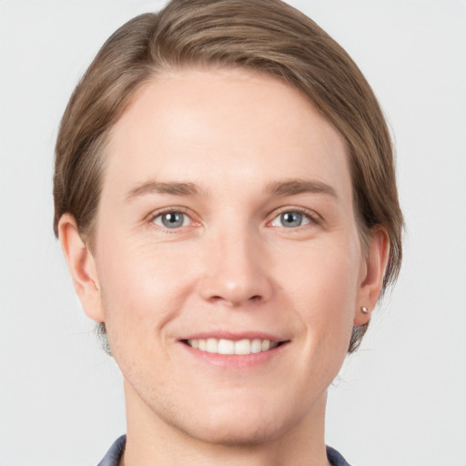 Joyful white young-adult male with short  brown hair and grey eyes