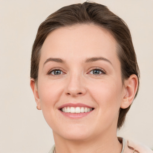 Joyful white young-adult female with medium  brown hair and grey eyes