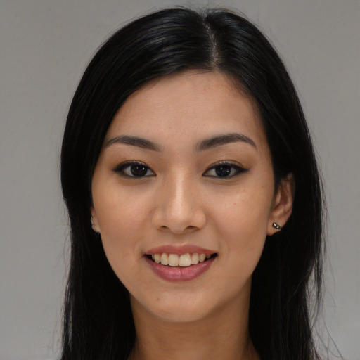 Joyful asian young-adult female with long  black hair and brown eyes