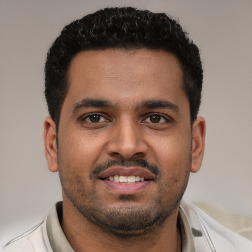 Joyful latino young-adult male with short  black hair and brown eyes