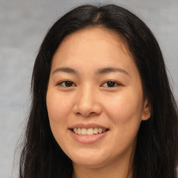 Joyful asian young-adult female with long  brown hair and brown eyes