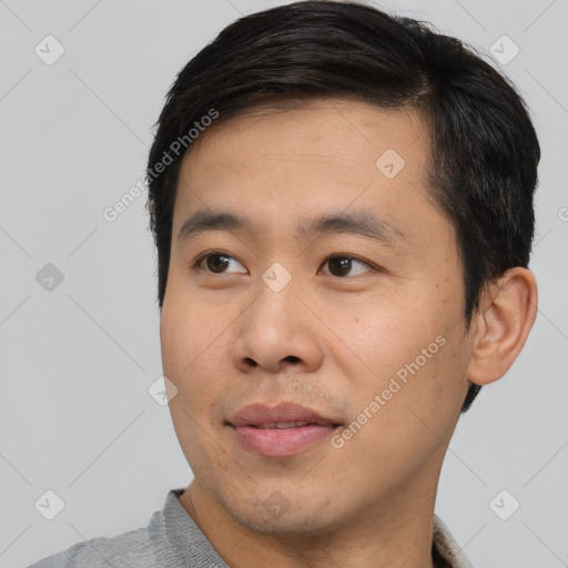 Joyful asian young-adult male with short  black hair and brown eyes