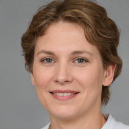 Joyful white adult female with medium  brown hair and grey eyes