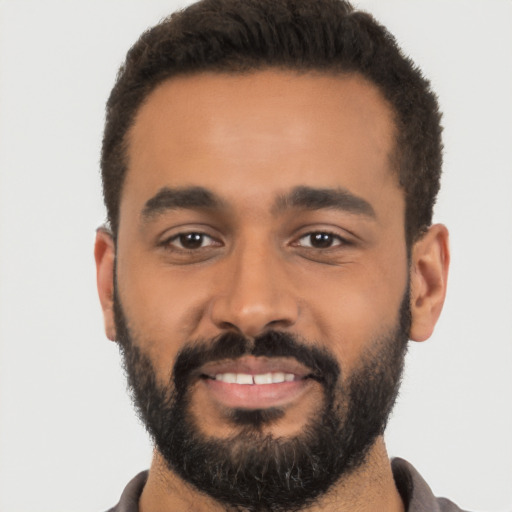 Joyful latino young-adult male with short  black hair and brown eyes